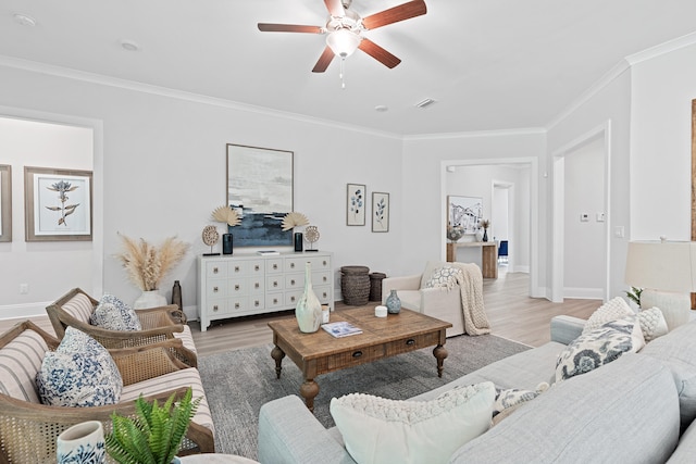 living room featuring light hardwood / wood-style floors, ceiling fan, and ornamental molding