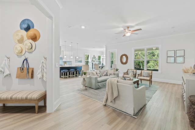 living room with ceiling fan, light hardwood / wood-style flooring, and crown molding