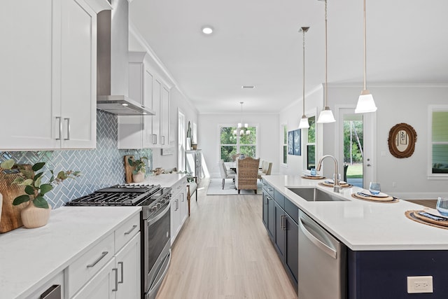 kitchen featuring white cabinets, stainless steel appliances, sink, and hanging light fixtures