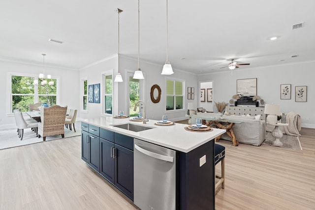 kitchen with stainless steel dishwasher, sink, a kitchen island with sink, and hanging light fixtures