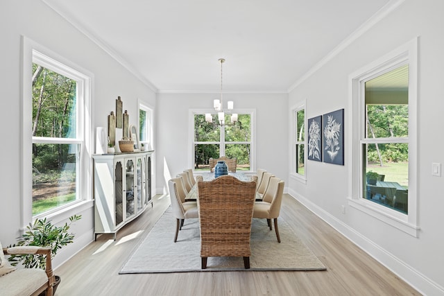 dining area with an inviting chandelier, a wealth of natural light, and crown molding