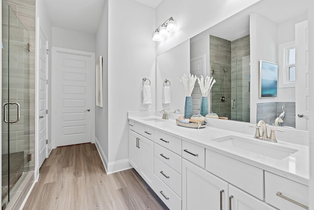 bathroom with vanity, a shower with shower door, and hardwood / wood-style flooring