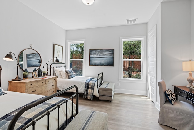 bedroom featuring light hardwood / wood-style floors and multiple windows