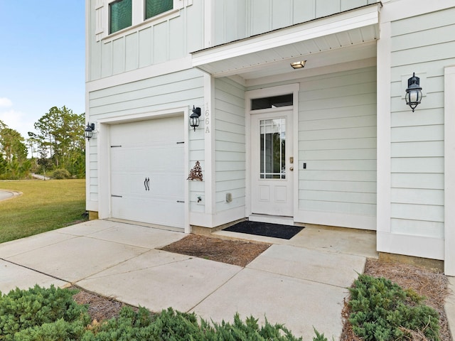 view of exterior entry featuring a lawn and a garage