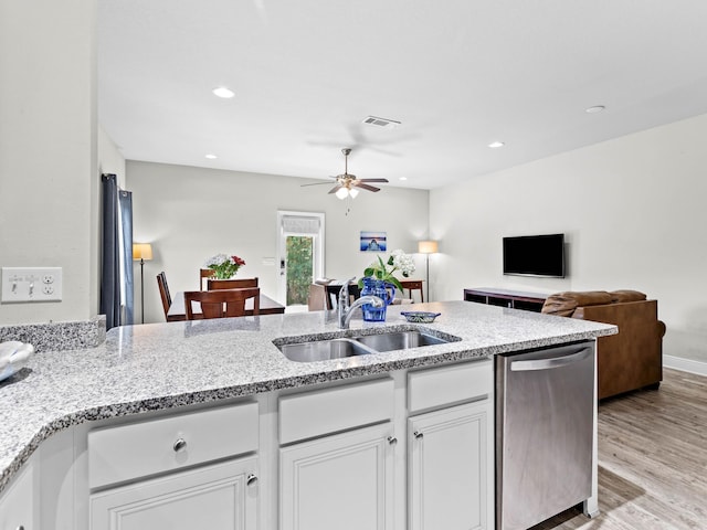 kitchen with white cabinetry, sink, light stone counters, stainless steel dishwasher, and light wood-type flooring