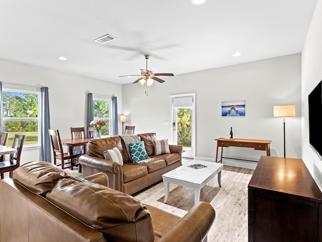 living room featuring ceiling fan, a wealth of natural light, and light hardwood / wood-style flooring