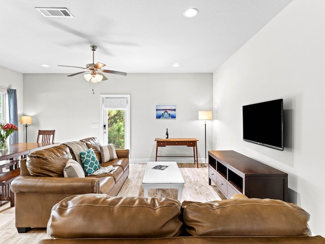 living room featuring light hardwood / wood-style flooring and ceiling fan