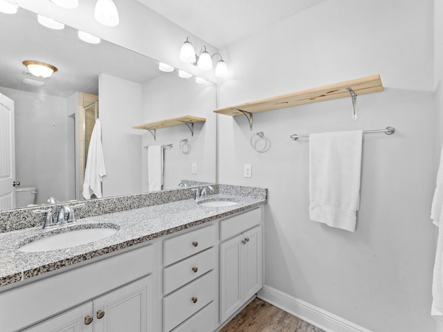 bathroom with wood-type flooring, vanity, toilet, and an enclosed shower