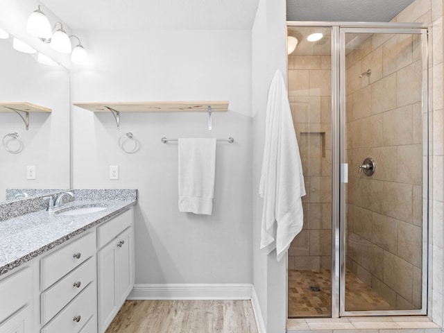 bathroom featuring a shower with door, vanity, and wood-type flooring