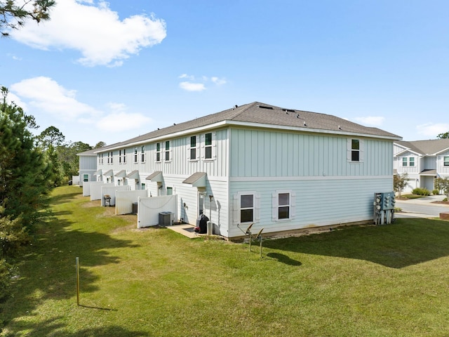 back of property featuring a yard and central air condition unit