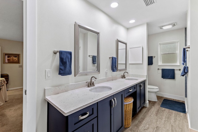 bathroom featuring vanity, toilet, and wood-type flooring