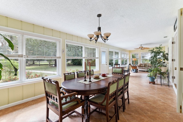 sunroom / solarium with plenty of natural light and ceiling fan with notable chandelier