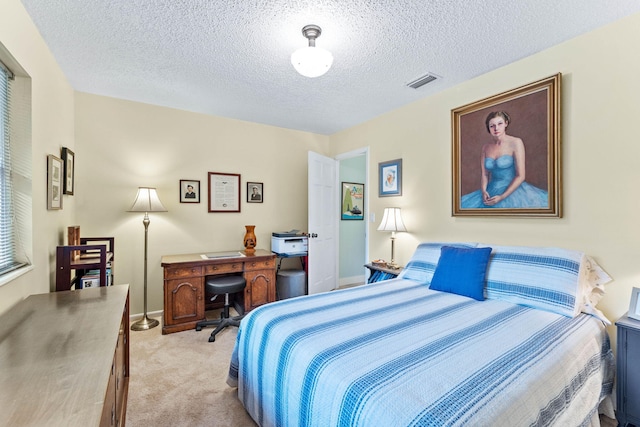 bedroom with a textured ceiling and light carpet