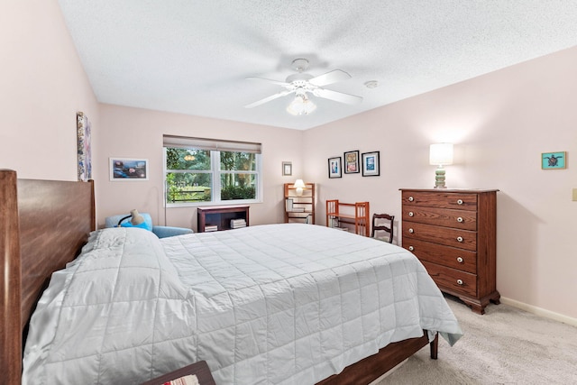 bedroom featuring ceiling fan, light carpet, and a textured ceiling