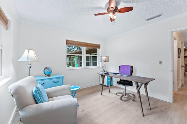 home office featuring ceiling fan, light hardwood / wood-style floors, a textured ceiling, and ornamental molding