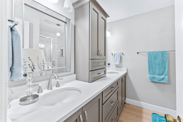 bathroom with wood-type flooring, vanity, and walk in shower