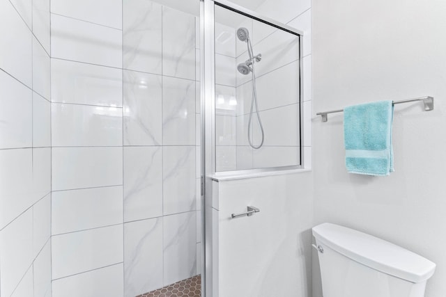 bathroom with toilet and a tile shower