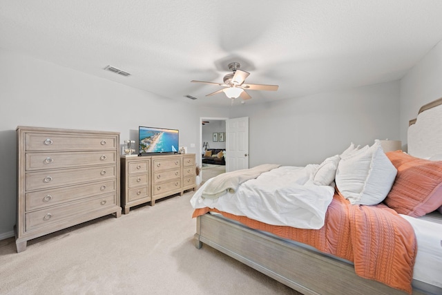 carpeted bedroom featuring ceiling fan and a textured ceiling