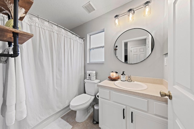 bathroom featuring toilet, vanity, a textured ceiling, and tile patterned floors