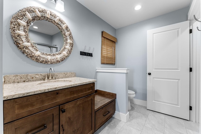 bathroom with vanity, toilet, and baseboards