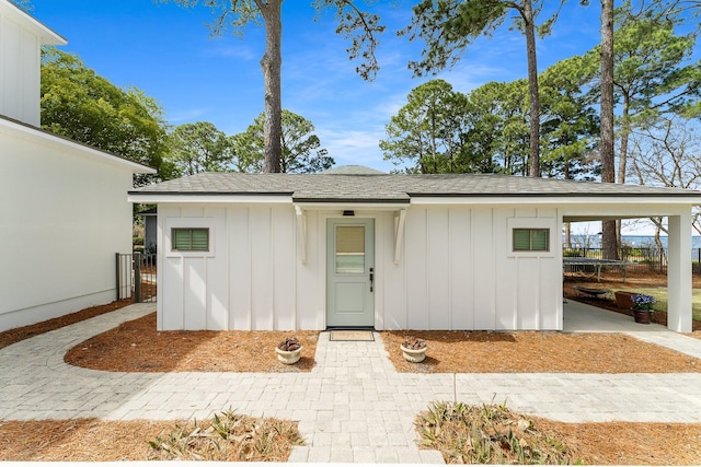 exterior space with board and batten siding and roof with shingles