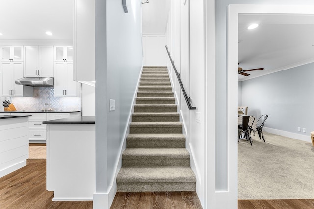 staircase with ornamental molding, recessed lighting, wood finished floors, and baseboards