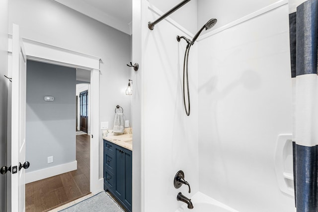 full bathroom with shower / washtub combination, wood finished floors, vanity, and baseboards