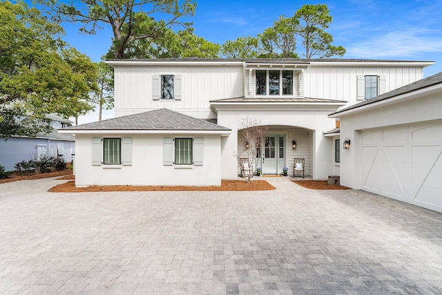 view of front of home with a standing seam roof, metal roof, decorative driveway, and an attached garage