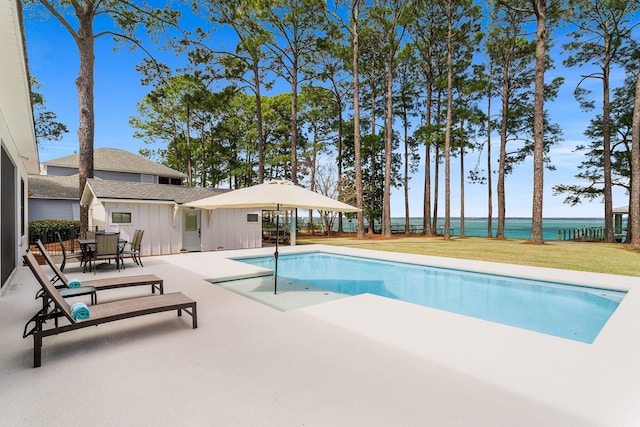 pool featuring a patio area, outdoor dining area, and a lawn