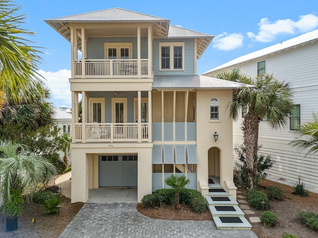 coastal inspired home featuring a garage and a balcony