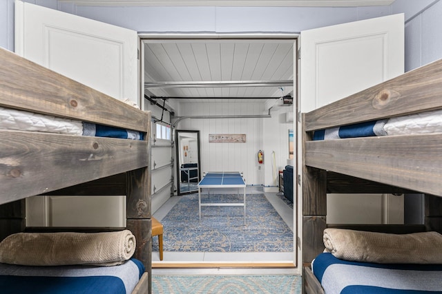 interior space with beam ceiling and wood walls