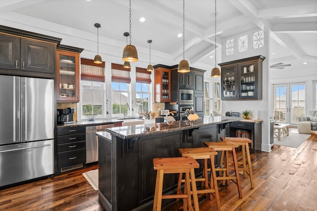 kitchen with a kitchen breakfast bar, a center island, dark hardwood / wood-style floors, and appliances with stainless steel finishes