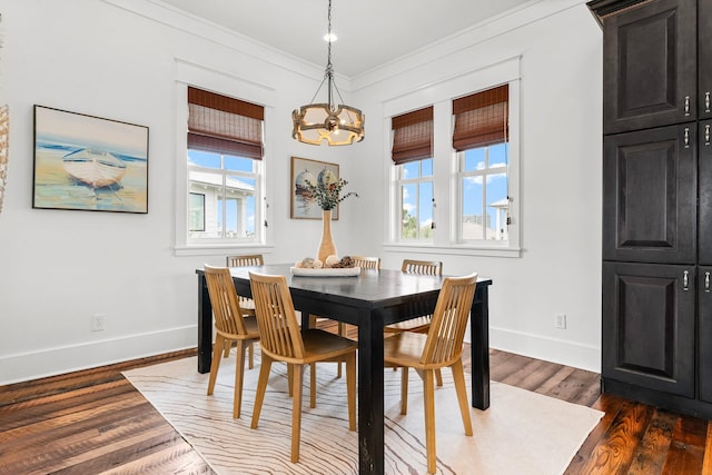 dining room featuring dark hardwood / wood-style floors, crown molding, and a notable chandelier