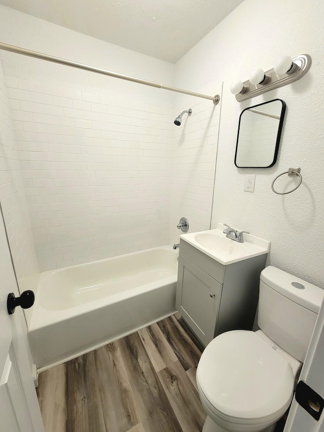 full bathroom featuring vanity, hardwood / wood-style floors, toilet, and tiled shower / bath