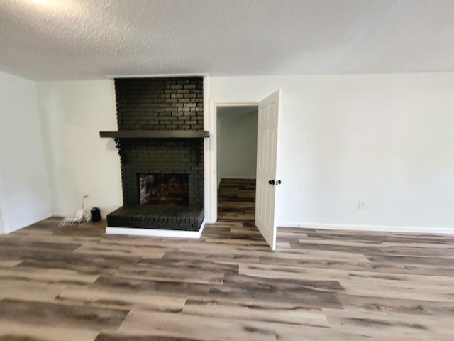 living room featuring a fireplace, hardwood / wood-style floors, and a textured ceiling