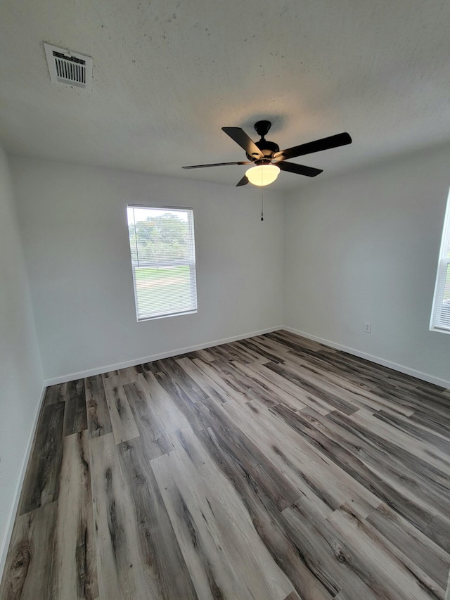 spare room featuring ceiling fan, wood-type flooring, and a textured ceiling