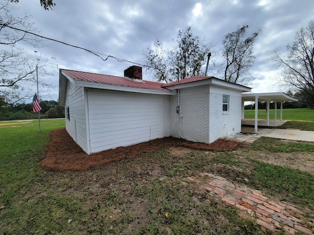 exterior space with a lawn and a carport