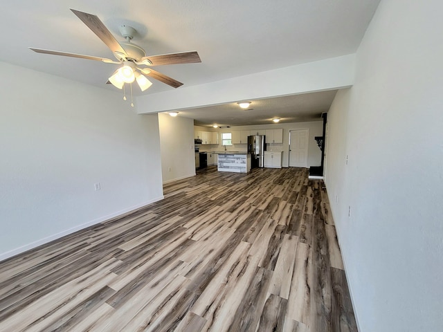 unfurnished living room featuring ceiling fan and light hardwood / wood-style floors