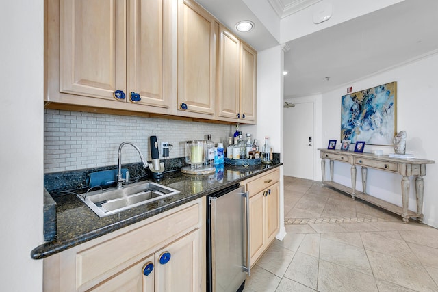 kitchen featuring stainless steel refrigerator, sink, tasteful backsplash, dark stone countertops, and light brown cabinetry