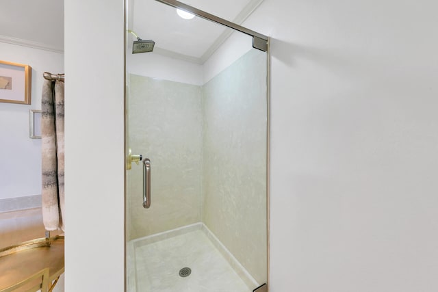 bathroom with an enclosed shower and ornamental molding