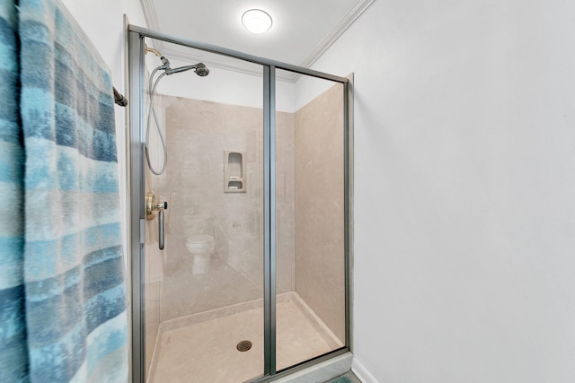 bathroom featuring ornamental molding and a shower with door