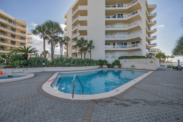 view of swimming pool featuring a patio area and a hot tub