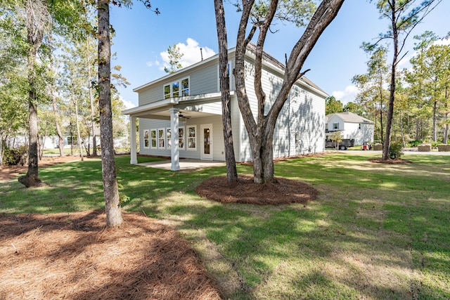 rear view of house with a yard and ceiling fan