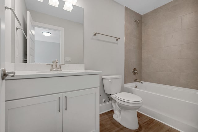 full bathroom with tiled shower / bath combo, toilet, wood-type flooring, and vanity