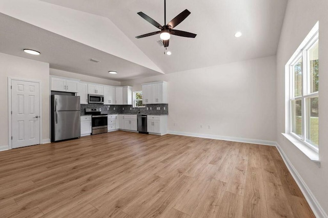 kitchen with backsplash, white cabinets, light hardwood / wood-style flooring, ceiling fan, and appliances with stainless steel finishes