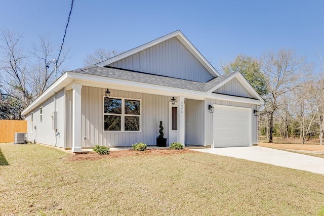 view of front of house with a garage, covered porch, cooling unit, and a front yard