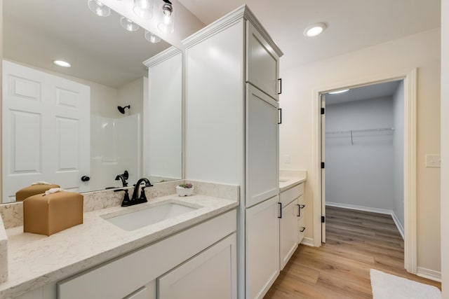 bathroom with vanity, hardwood / wood-style floors, and a shower