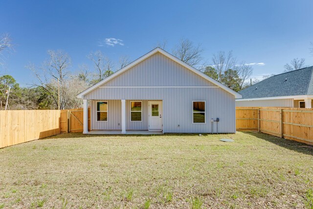 back of property featuring a lawn