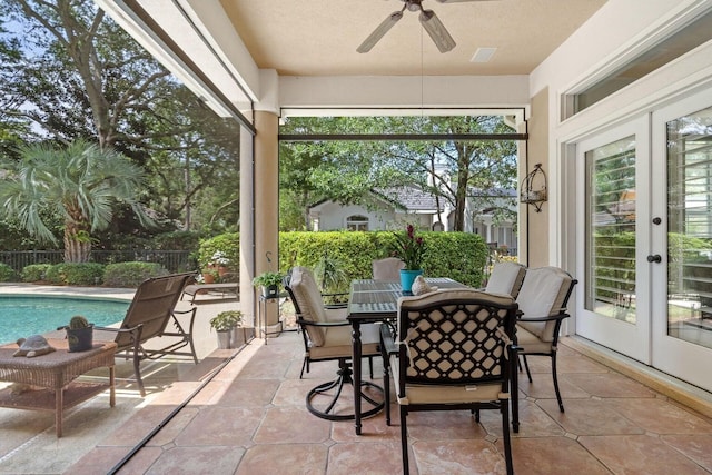 sunroom / solarium featuring a wealth of natural light, french doors, and ceiling fan