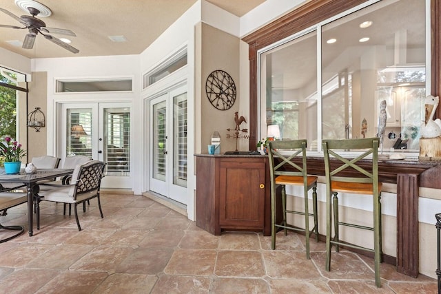 sunroom featuring ceiling fan and french doors